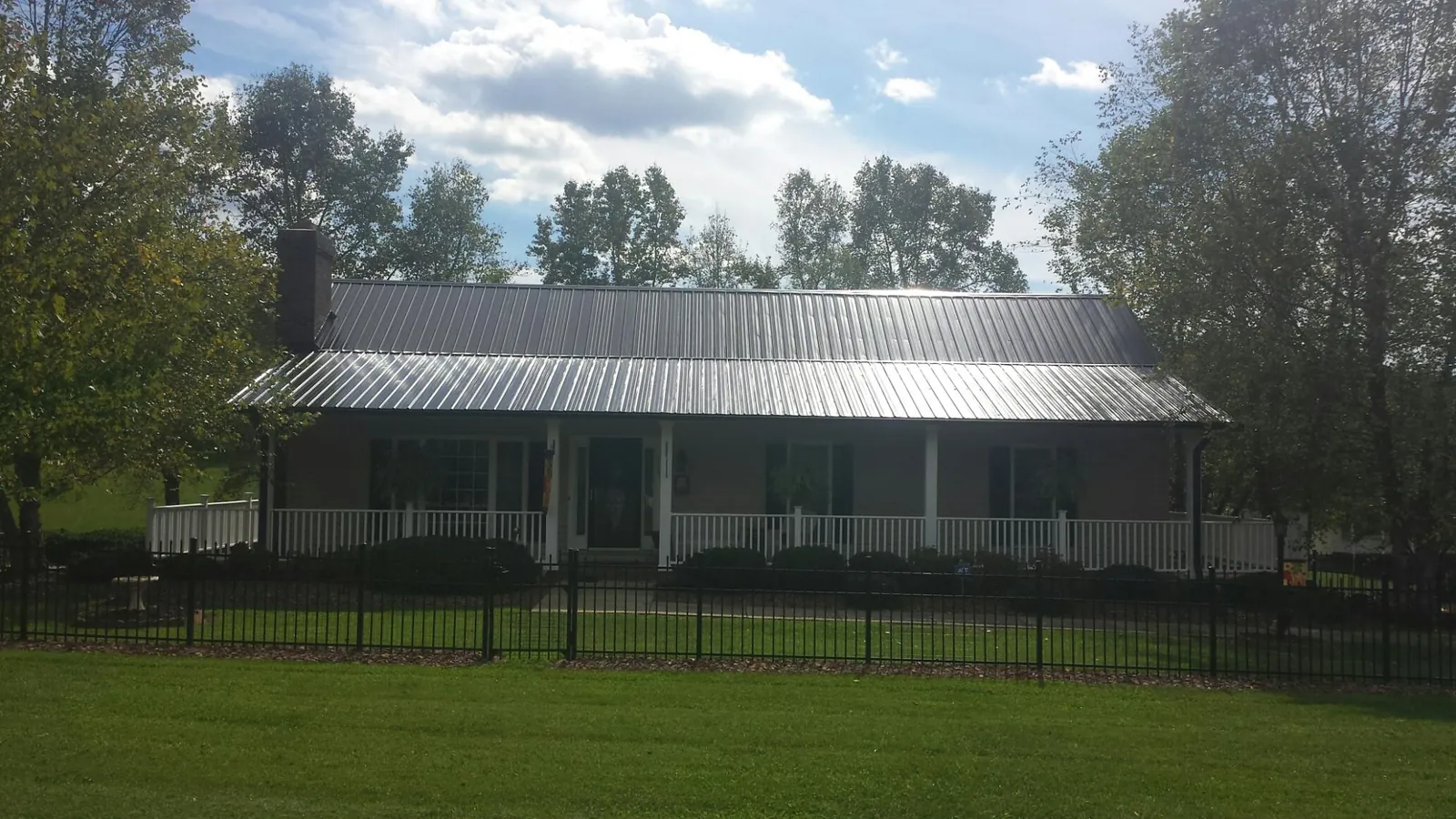Gray metal roof on a brick ranch with a full width front porch — Gutter Guard Installation work by our crew in Yorkville